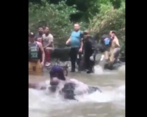 Migrante con niño en brazos lucha contra el río en el Darién