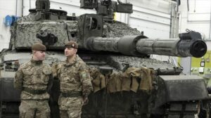 Dos militares al lado de un tanque, durante la reunión previa en Estonia.
