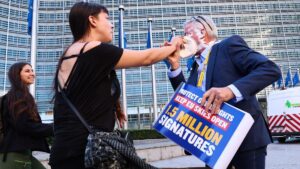 Activistas arrojan una tarta al CEO de Ryanair en Bruselas. En la foto, el momento del tartazo. En el vídeo, Michael O’Leary se limpia los restos de tarta.