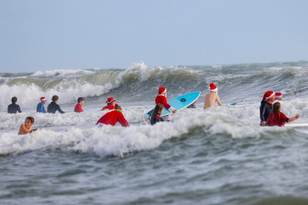 En tablas de surf, Papás Noel toman playa en Florida por diversión y una buena causa (FOTOS)
