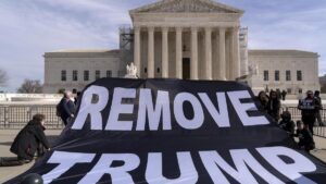 Un grupo de manifestantes despliega un cartel que pide sacar a Trump de la carrera electoral, este jueves frente al Tribunal Supremo.