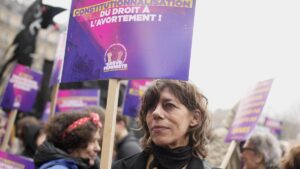 Una mujer muestra un cartel reclamando la inclusión en la Constitución del &quot;derecho al aborto&quot;, durante la manifestación del pasado 8 de marzo en París.