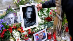 Una mujer coloca una fotografía de Alekséi Navalni en el memorial en su memoria en Las Ramblas de Barcelona.