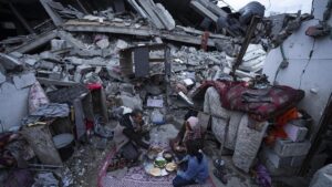 Una familia de gazatíes rompe el ayuno del Ramadán en el exterior de su casa destruida por un bombardeo israelí, este lunes.