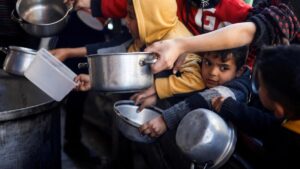 Un grupo de niños esperan a recibir comida de una organización humanitaria en Rafah, este martes.
