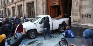 Manifestantes de Ayotzinapa derriban con un vehículo la puerta del palacio presidencial en México