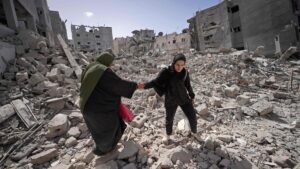 Mujeres palestinas entre ruinas de edificios bombardeados en ataques israelís en Khan Yunis, al sur de la Franja de Gaza