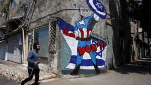 Un hombre pasa junto a un grafiti de Biden dibujado como el superhéroe Capitán América en una calle de Tel Aviv.