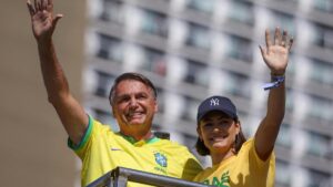 Jair Bolsonaro, acompañado por su esposa Michelle, saluda mientras asiste a una manifestación en la que convocó a sus seguidores en la playa de Copacabana, en Río de Janeiro.