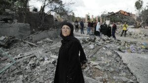 Residentes del pueblo de Aita al -Shaab, en el sur del Líbano, pasan junto a un edificio destruido por bombardeos israelíes.