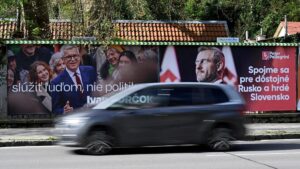 Un vehículo pasa junto a carteles electorales de los candidatos Ivan Korkok y Peter Pellegrini, este viernes en Trencin.