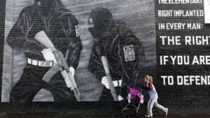 Una mujer pasa junto a un mural de un grupo paramilitar unionista en Belfast.