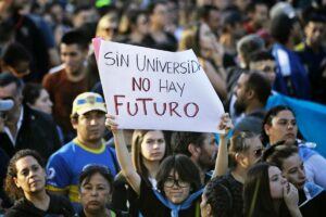 A demonstrator holds a sign that reads &quot;Without university there is no future&quot; during a march in protest of the budget adjustment to public universities in Buenos Aires on April 23, 2024. Thousands of university students took to the streets of Argentina on Tuesday to repudiate the defunding of the public university, which was declared in a state of budgetary emergency in the framework of the adjustment policy of the right-wing president Javier Milei. (Photo by Emiliano Lasalvia / AFP)