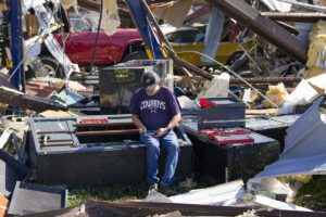 Un empleado de un taller de carrocería recuperar unas herramientas tras ser devastado el taller mecánico por los tornados.un tornado