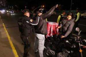 Policías ecuatorianos revisan los documentos de un motociclista en una calle antes de un apagón nacional programado en Quito, el 18 de septiembre de 2024