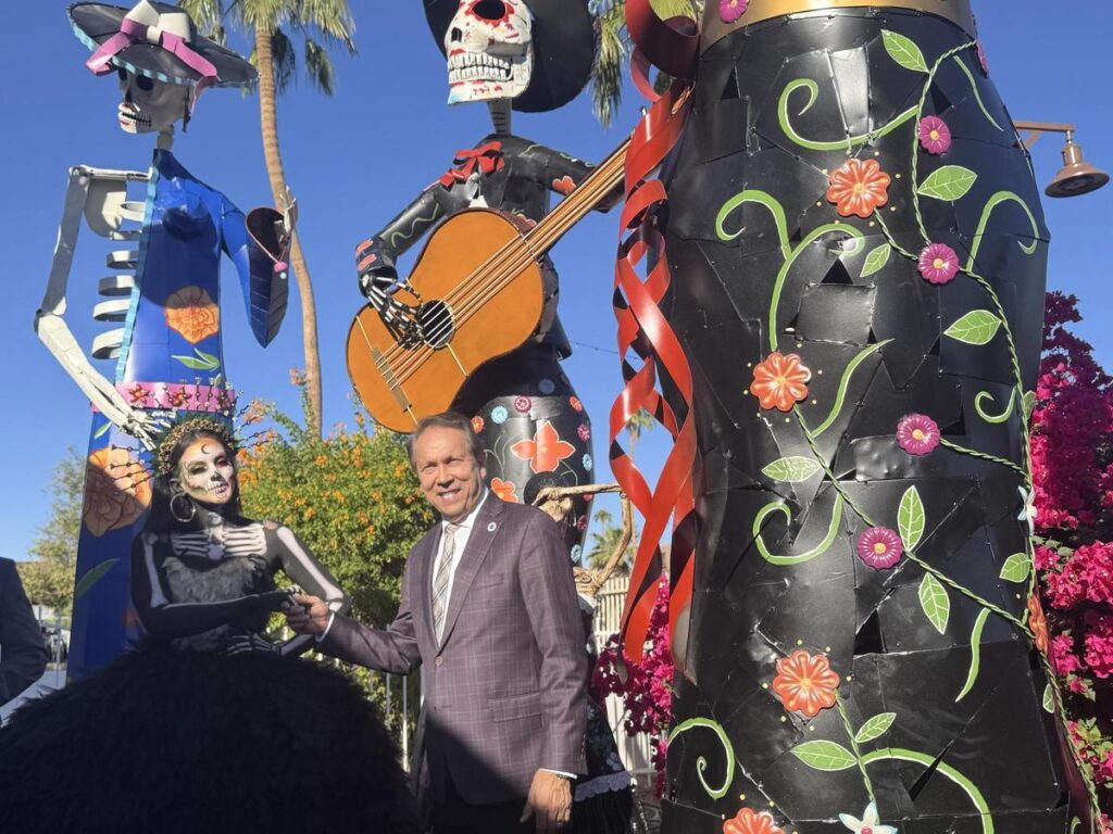 El alcalde de Scottsdale, David Ortega, saluda a una figurante de una instalación del Día de Muertos.