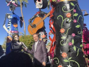 El alcalde de Scottsdale, David Ortega, saluda a una figurante de una instalación del Día de Muertos.