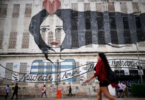 Una mujer camina delante de un murual en el bulevard donde se celegra la cumbre social del G20, en Rio de Janeiro.