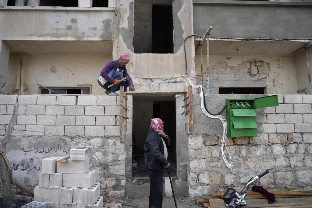 Un hombre trabaja en la reconstrucción de una vivienda en Idlib.