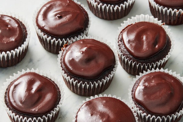 Imagen cenital de magdalenas de chocolate cubiertas con glaseado de chocolate.