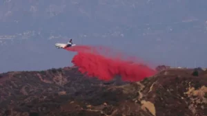 Un avión esparce el polvo rosa sobre las montañas de California
