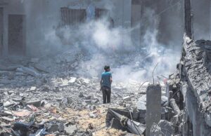 Un joven observa la destrucción de un edificio en Gaza, este martes, en un nuevo ataque israelí.