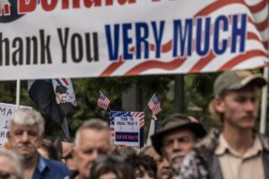 (FILES) White South Africans supporting US President Donald Trump and South African and US tech billionaire Elon Musk gather in front of the US Embassy in Pretoria, on February 15, 2025 for a demonstration. The white Afrikaners who have accepted resettlement in the United States did not face "any form of persecution" in South Africa, the foreign ministry said on May 12, 2025. It came hours after a first group of 49 white South Africans flew out of Johannesburg following US President Donald Trump's offer to grant refugee status to white Afrikaners. (Photo by MARCO LONGARI / AFP)