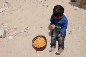 Un niño palestino junto a una ración de comida en Gaza. 12 de mayo de 2025.