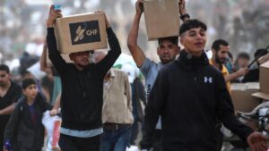 Palestinos cargan cajas con ayuda entregada por la Fundación Humanitaria de Gaza, este domingo en el centro de Gaza.