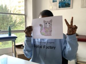 Una chica acogida en el centro de MSF a las afueras de París muestra un dibujo que ha pintado.
