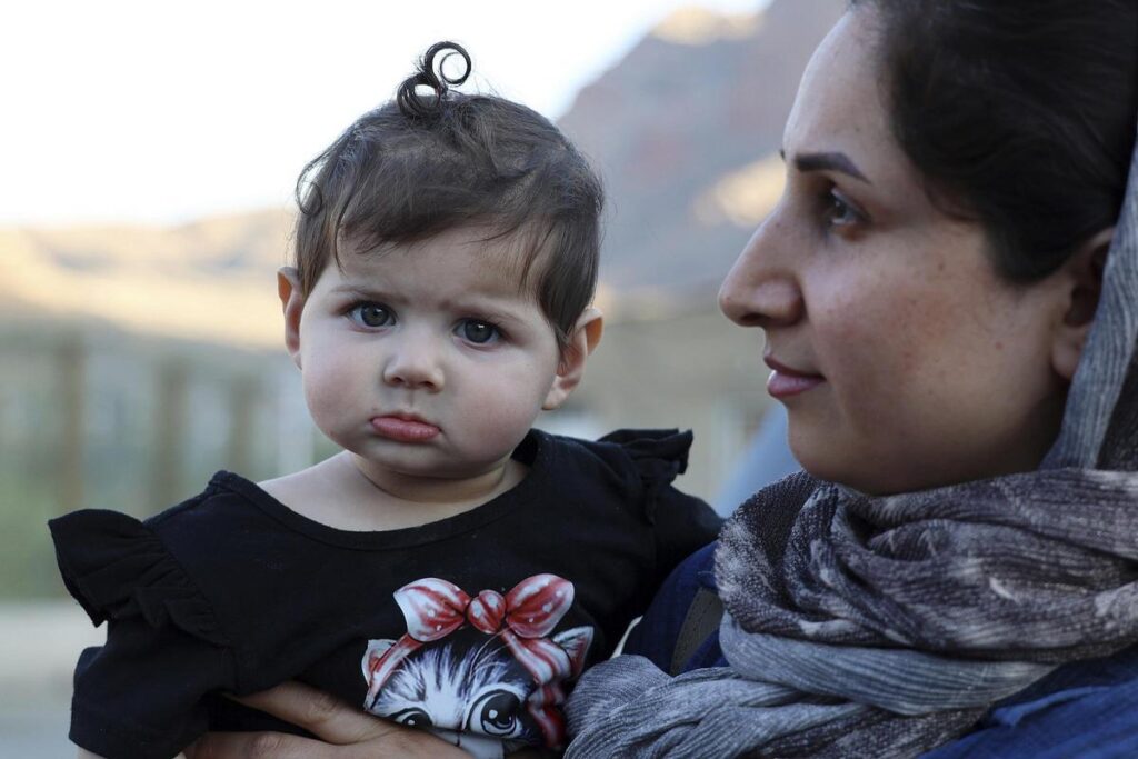 Una iraní con su pequeña cerca del cruce entre Armenia e Irán en el pueblo de Agarak.