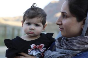 Una iraní con su pequeña cerca del cruce entre Armenia e Irán en el pueblo de Agarak.