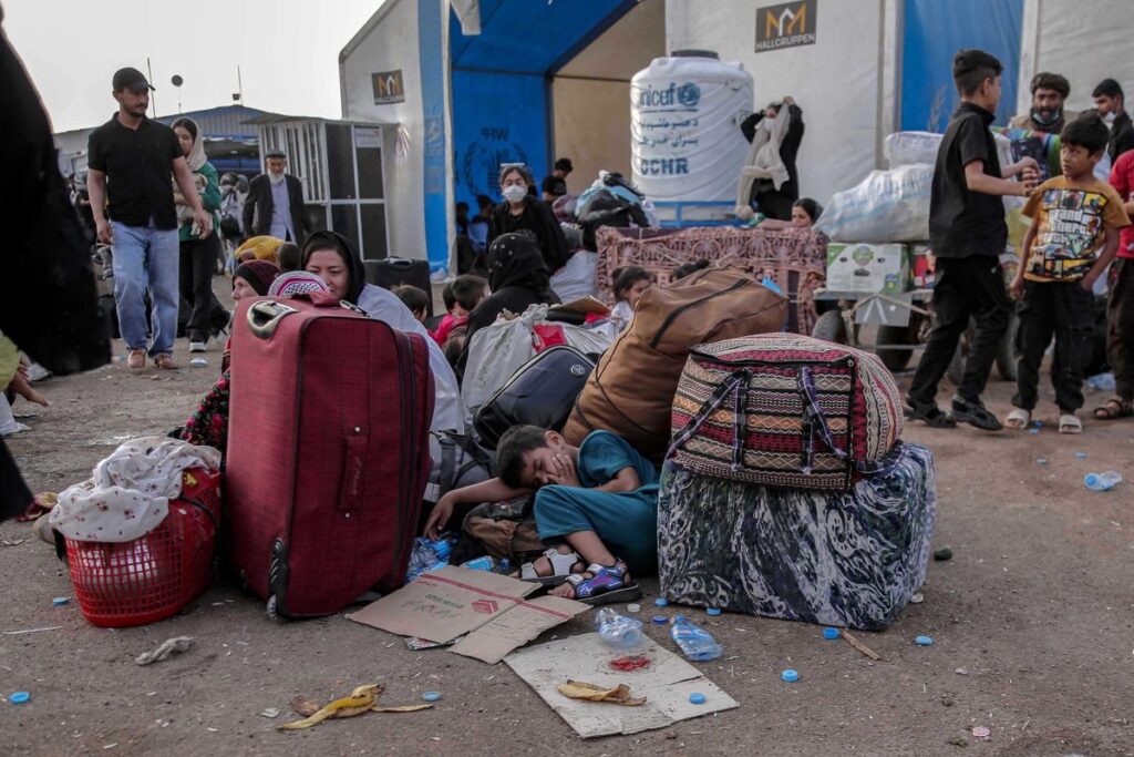 Refugiados afganos, repatriados desde Irán, esperan en el paso fronterizo de Islam Qala, en la provincia afgana de Herat.