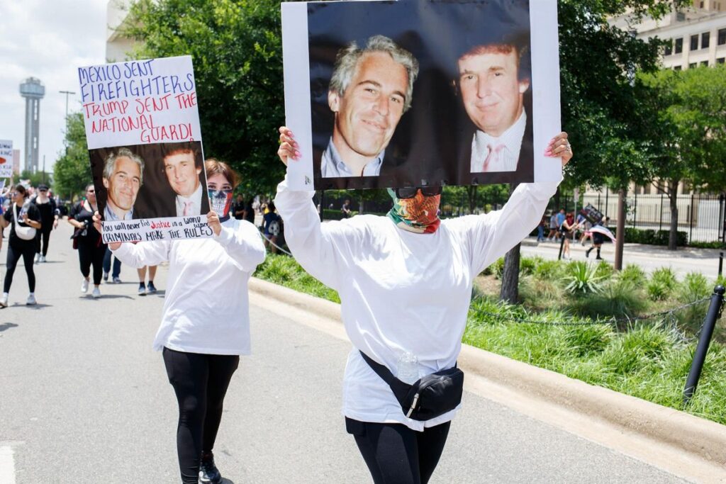 Archivo - Dos manifestantes alzan pancartas con la fotografía de Donald Trump y Jeffrey Epstein