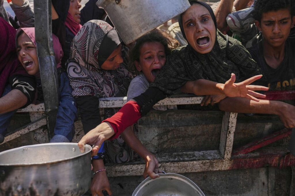 Palestinians struggle to get donated food at a community kitchen in Gaza City, northern Gaza Strip, Monday, Aug. 4, 2025. (AP Photo/Jehad Alshrafi) Associated Press/LaPresse. EDITORIAL USE ONLY/ONLY ITALY AND SPAIN