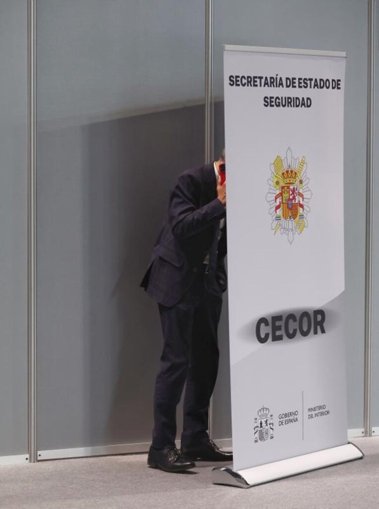 El ministro del Interior, Fernando Grande-Marlaska, busca intimidad para una llamada en un Centro de Coordinación de emergencias.