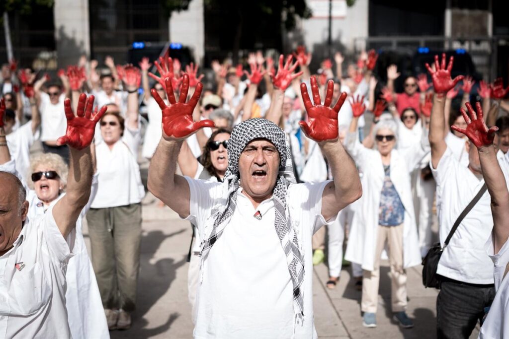 Sanitarios españoles homenajean a sus colegas en Gaza con batas blancas y manos pintadas de rojo