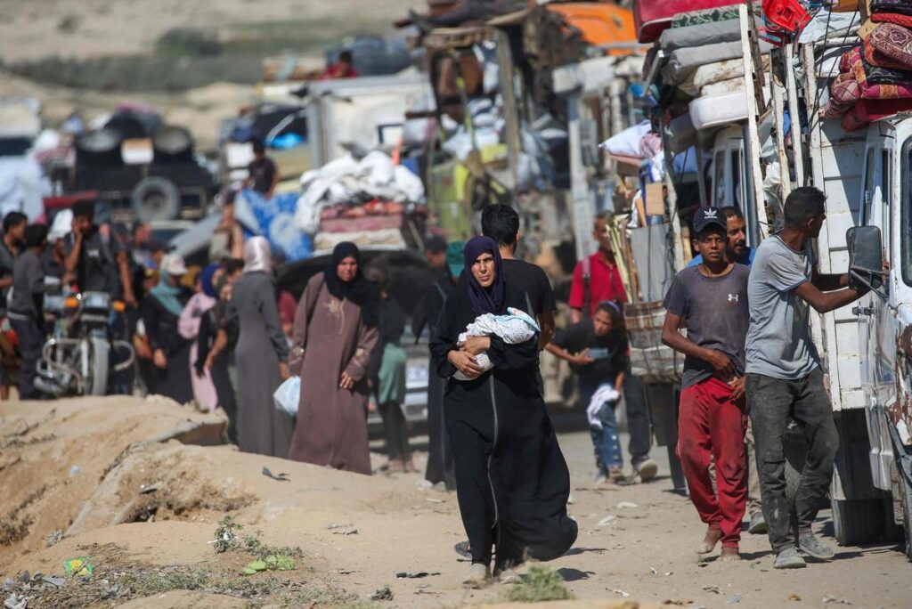 Palestinos desplazados se trasladan hacia el sur con sus pertenencias por una carretera en la zona del campo de refugiados de Nuseirat, en el centro de la Franja de Gaza.