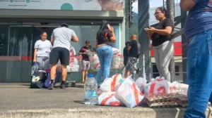 Caraqueños hacen cola para comprar medicinas, agua potable y comida