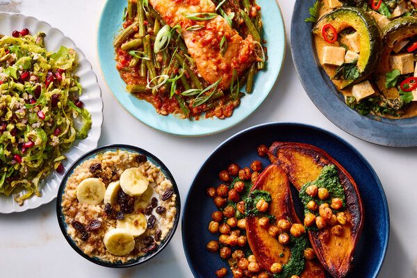 Cinco platos con distintos tipos de alimentos: avena con plátano, camote con garbanzo, curry de verduras, entre otros