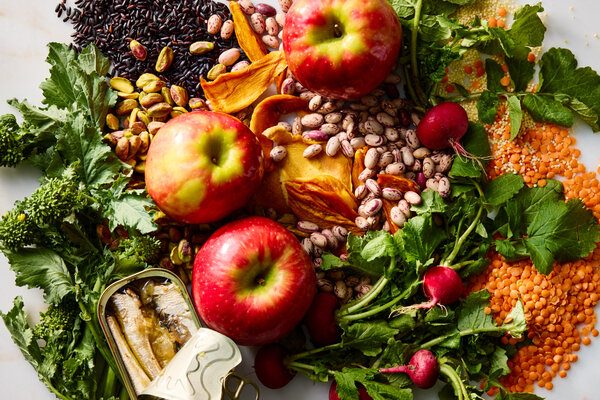 Una variedad de manzanas, rábanos, frijoles y otros alimentos sin procesar.