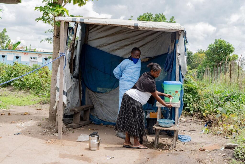Un trabajador sanitario enseña a una mujer cómo lavarse las manos en el hospital de Rwampara, en el este de la República Democrática de Congo.