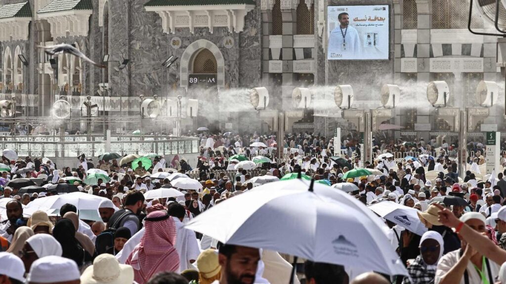 Fieles musulmanes caminan por el complejo de la Gran Mezquita bajo los ventiladores con pulverización de agua instalados en la ciudad santa de La Meca el 24 de mayo de 2026, antes de la peregrinación anual del hach.