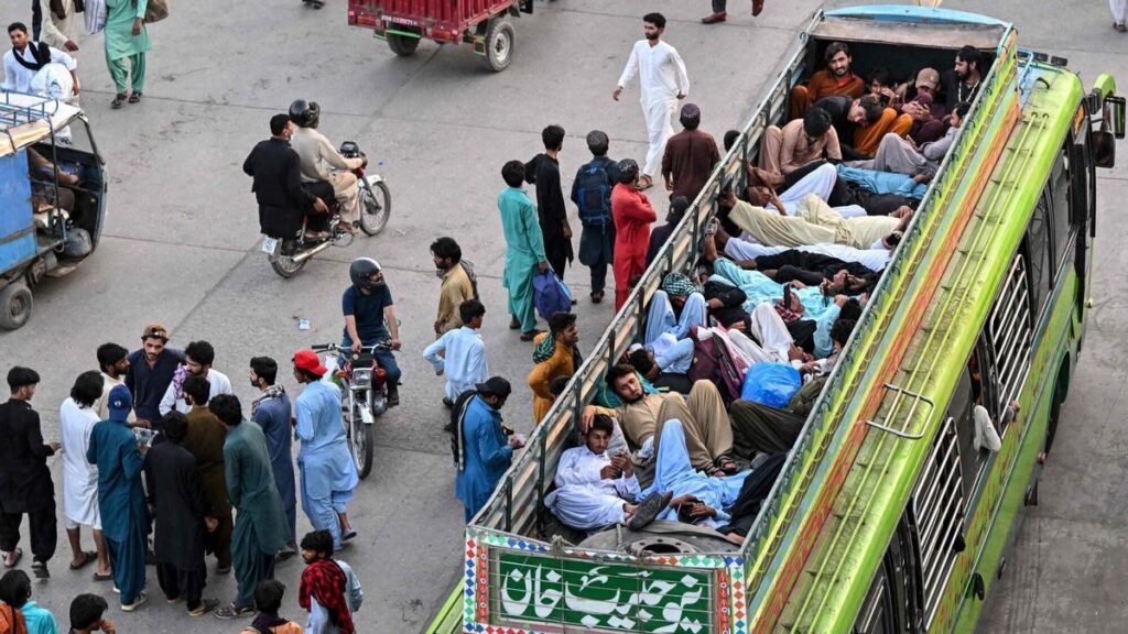 Personas viajan en un autobús abarrotado para regresar a sus ciudades de origen antes del Eid al-Adha en Lahore
