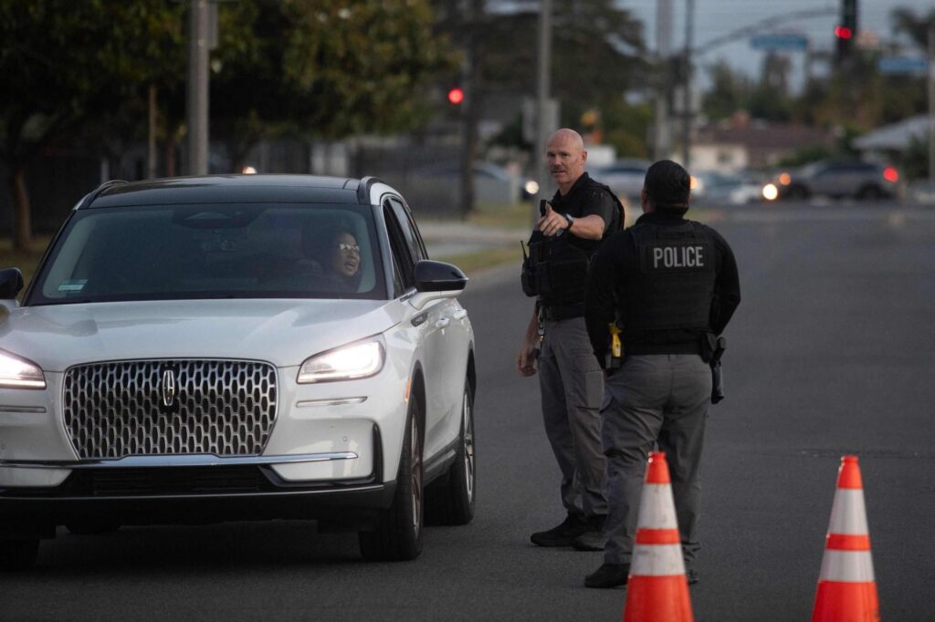Unos agentes de policía dirigen hacia un refugio a unos evacuados por la alerta química en California, Estados Unidos.
