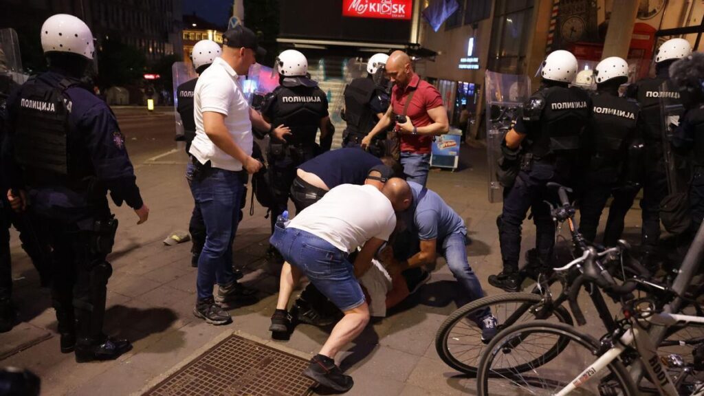 Agentes de policía detienen en Belgrado a un manifestante tras la protesta contra el Gobierno, este sábado.