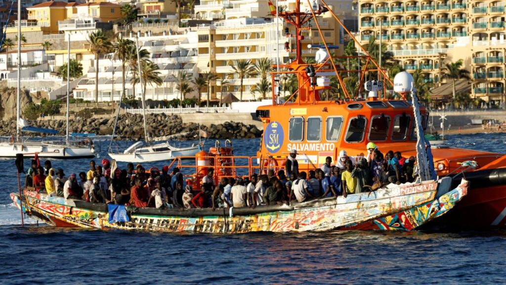 Un grupo de migrantes en una barca de madera son remolcados por una embarcación de la guardia costera española hasta el puerto de Arguineguín, en la isla de Gran Canaria, España, 21 de octubre de 2023. REUTERS