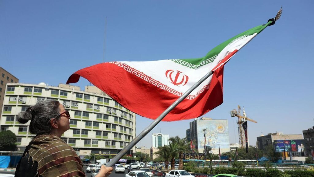Una mujer ondea la bandera iraní en una plaza de Teherán, este martes.