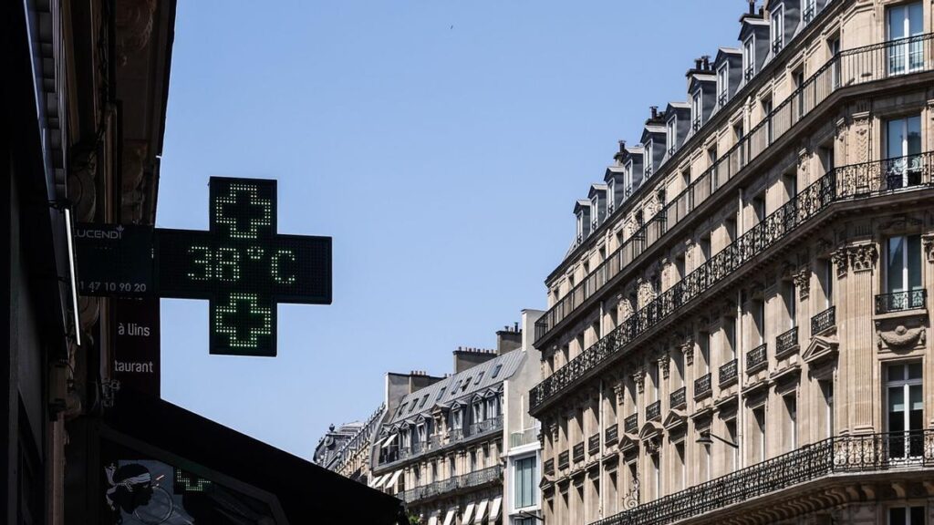 Un termómetro en una farmacia de París junto a los icónicos tejados de la ciudad, en plena ola de calor.