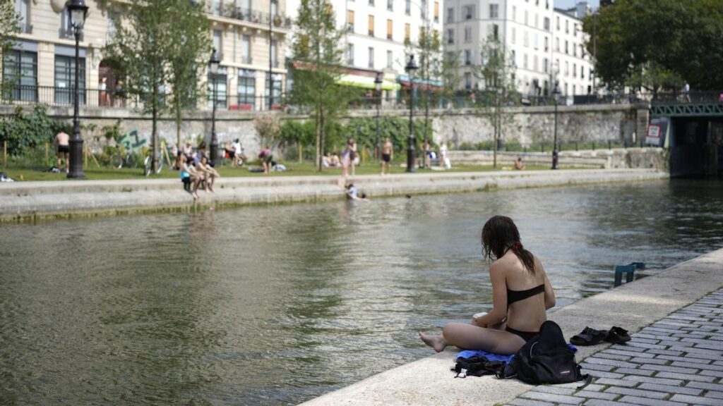 Varias personas se refrescan a orillas del Sena en París, este martes.